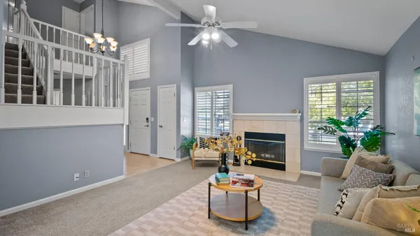 a living room with furniture a fireplace and a chandelier