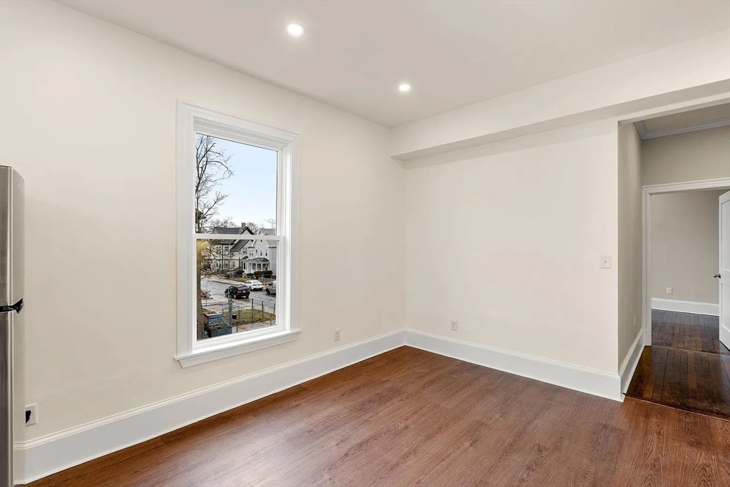 10 King Street, Unit 2 Boston, MA 02122 - Photo 6 of 17 an empty room with wooden floor and a window