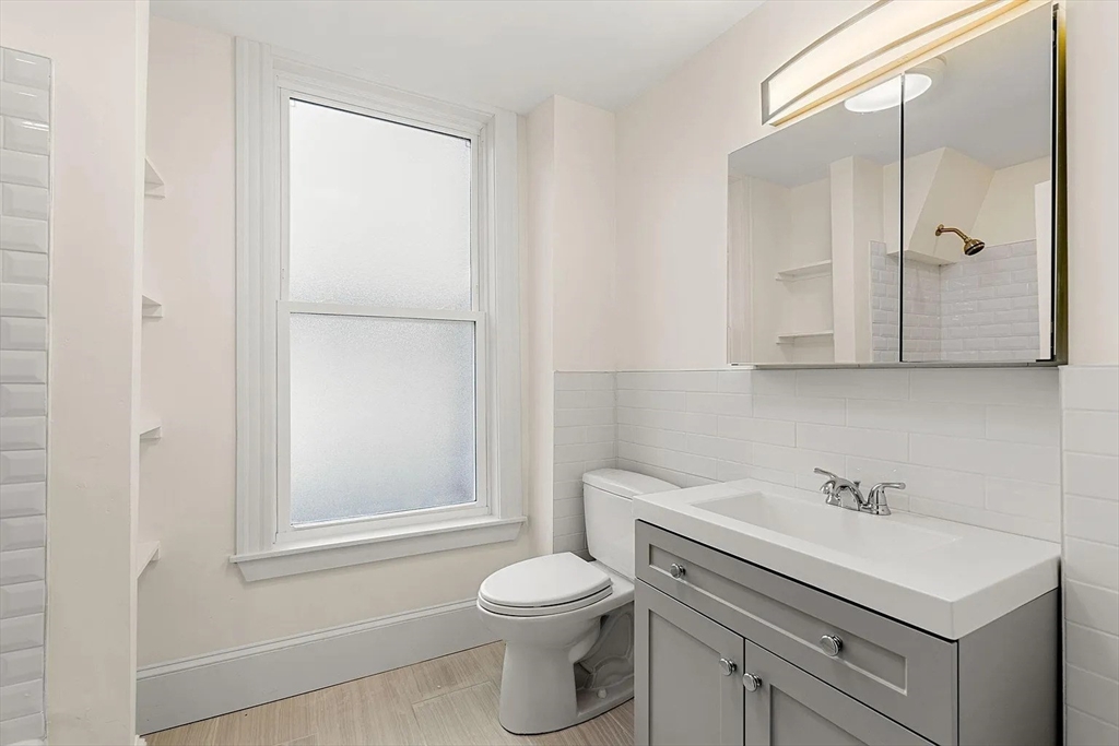 10 King Street, Unit 2 Boston, MA 02122 - Photo 10 of 17 a bathroom with a sink toilet vanity and shower