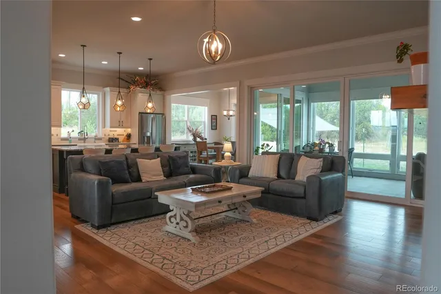 a living room with furniture chandelier and a large window