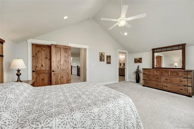 a bedroom with a large bed and a flat tv screen on dresser