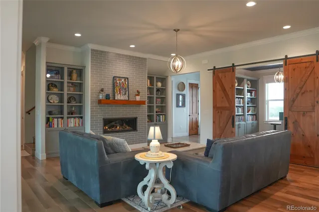 a living room with furniture a fireplace and a chandelier