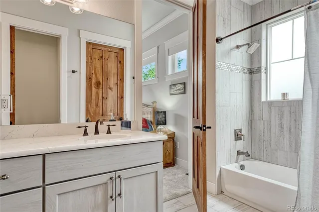 a bathroom with a tub sink and mirror