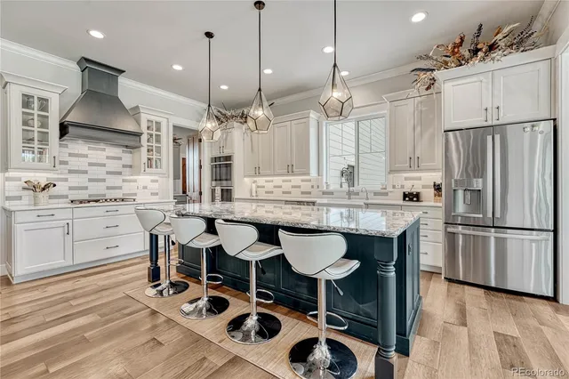 a kitchen with granite countertop a table chairs stove a sink and a refrigerator