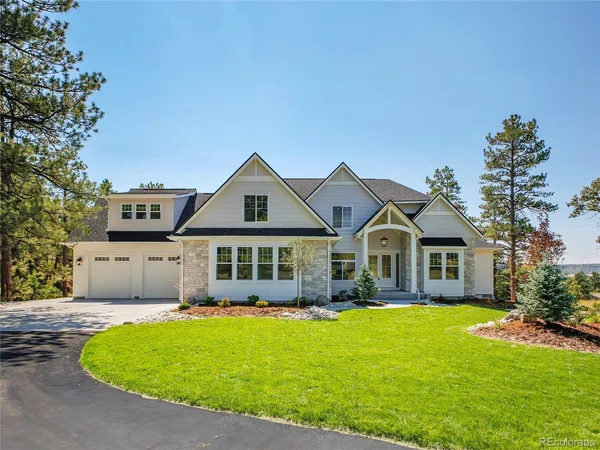 a front view of a house with a garden and yard