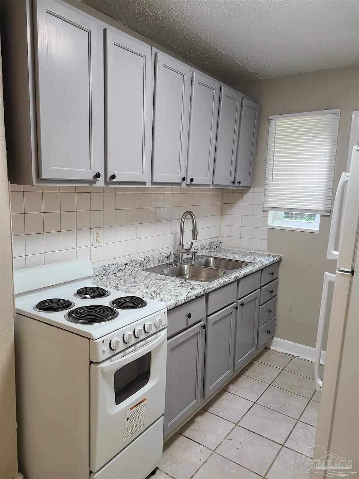612 McCarroll Road, Unit B Pensacola, FL 32507 - Photo 5 of 13 a kitchen with cabinets appliances and a sink