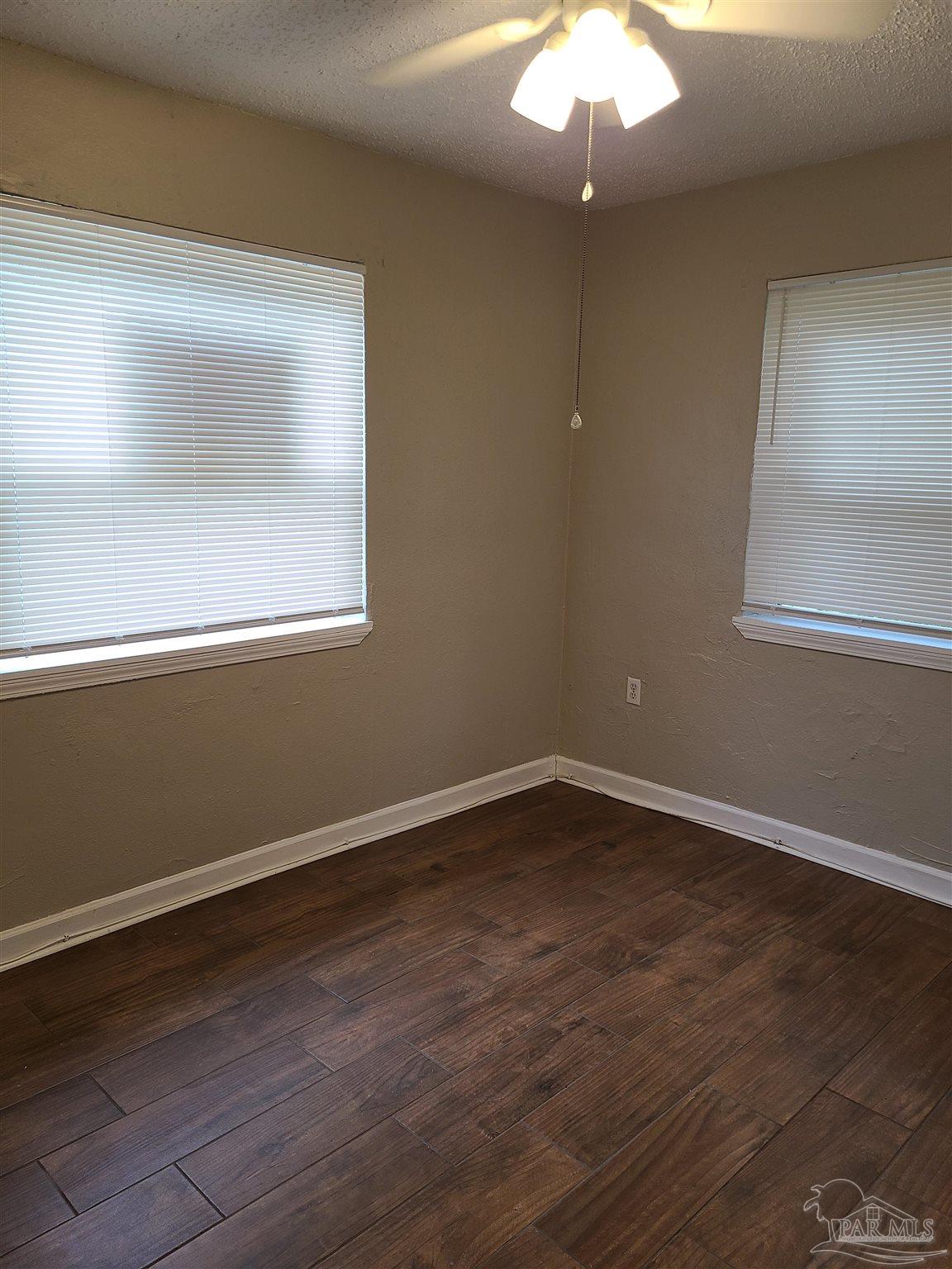 612 McCarroll Road, Unit B Pensacola, FL 32507 - Photo 7 of 13 a view of an empty room with wooden floor and a window