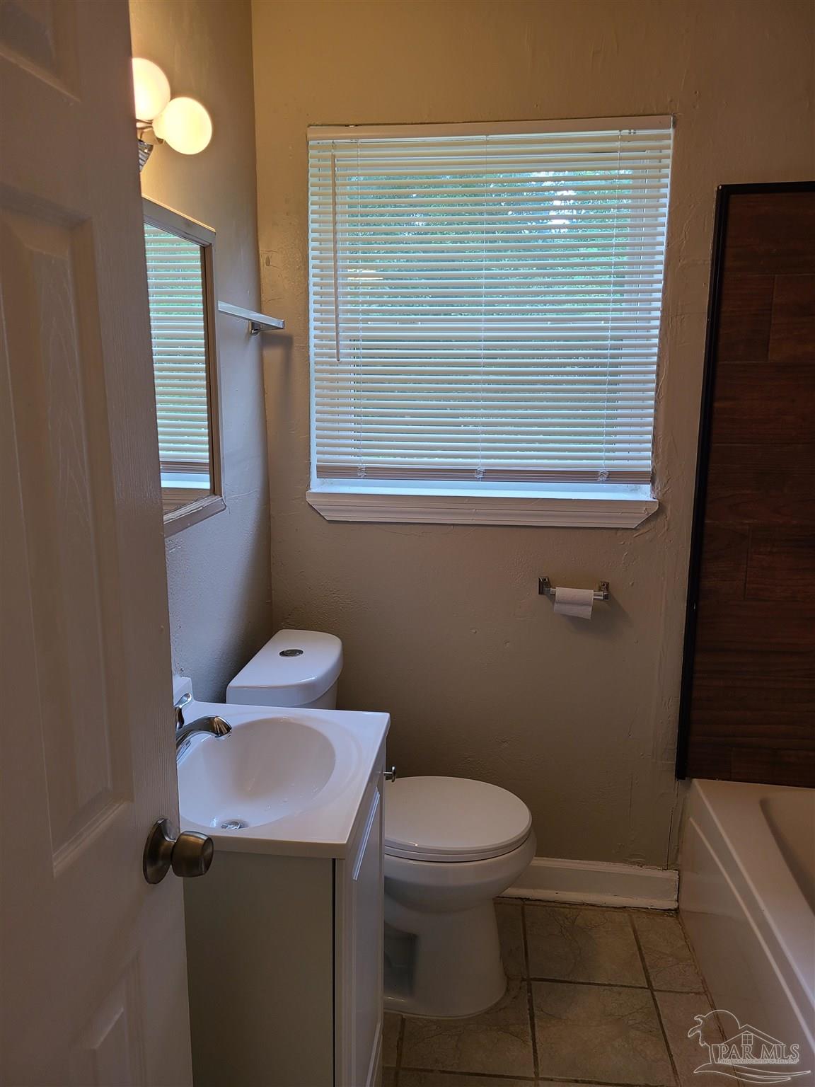 612 McCarroll Road, Unit B Pensacola, FL 32507 - Photo 9 of 13 a bathroom with a toilet a sink and shower