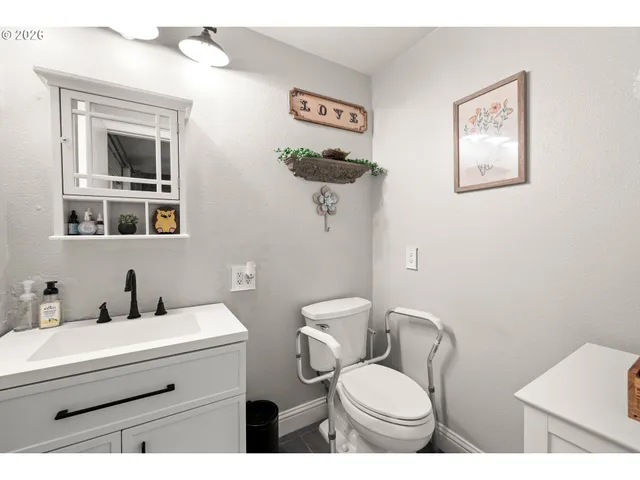 a bathroom with a toilet a sink and mirror
