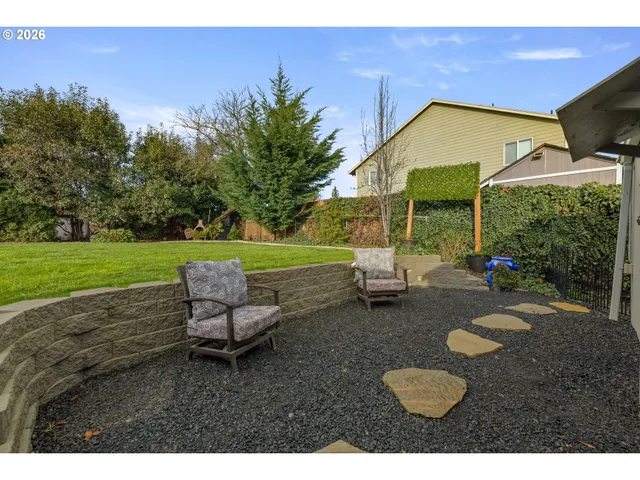 a view of a backyard with table and chairs under an umbrella