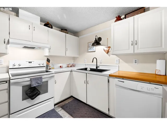 a kitchen with stainless steel appliances granite countertop a sink and cabinets with wooden floor