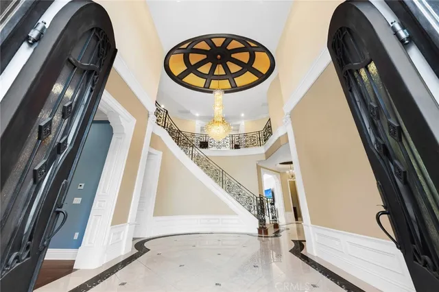 a view of an empty room with wooden floor and a kitchen