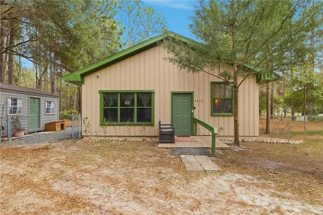 a view of a house with backyard and sitting area