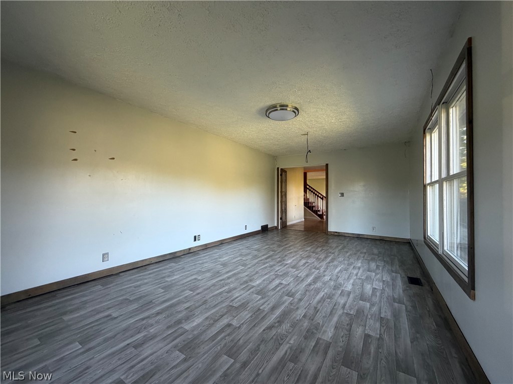 3950 Wolf Road Southwest Port Washington, OH 43837 - Photo 3 of 45 Spacious room featuring wood-finish flooring, a contemporary ceiling light fixture, and a multi-pane window with wood trim