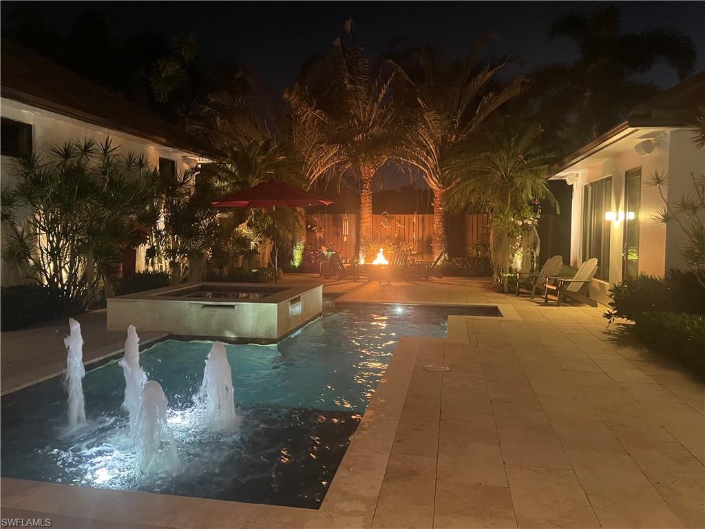 2296 Hawks Ridge Loop Naples, FL 34105 - Photo 49 of 50 Courtyard at night with water feature and firepit.