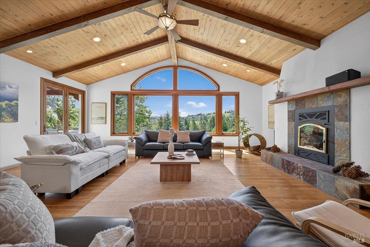 13404 Flora Ranch Road Healdsburg, CA 95448 - Photo 17 of 83 a living room with furniture a fireplace and a floor to ceiling window
