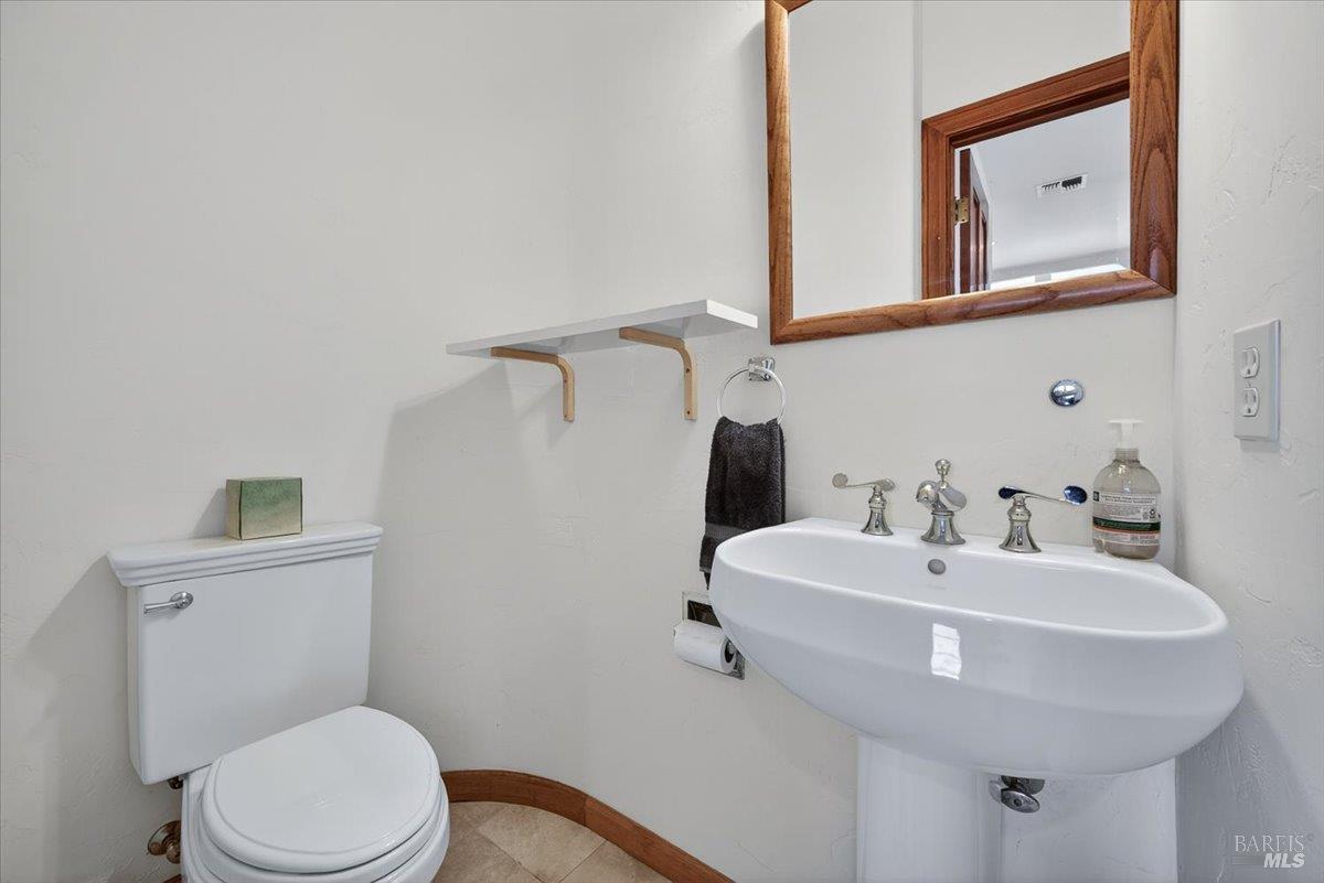13404 Flora Ranch Road Healdsburg, CA 95448 - Photo 57 of 83 a bathroom with a sink a mirror and a toilet