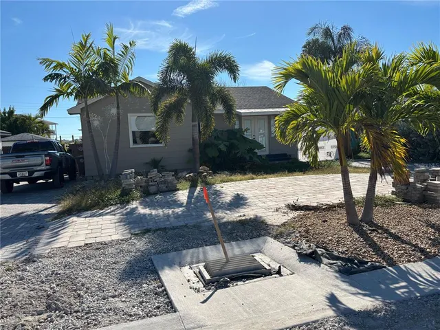 a view of a backyard with a fountain plants and palm trees