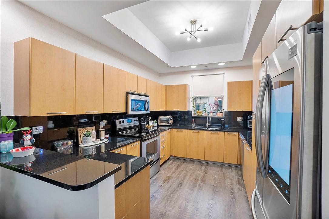 2330 Vintage Drive Lighthouse Point, FL 33064 - Photo 17 of 41 a kitchen with stainless steel appliances granite countertop a refrigerator a sink dishwasher a stove and a dining table with wooden floor