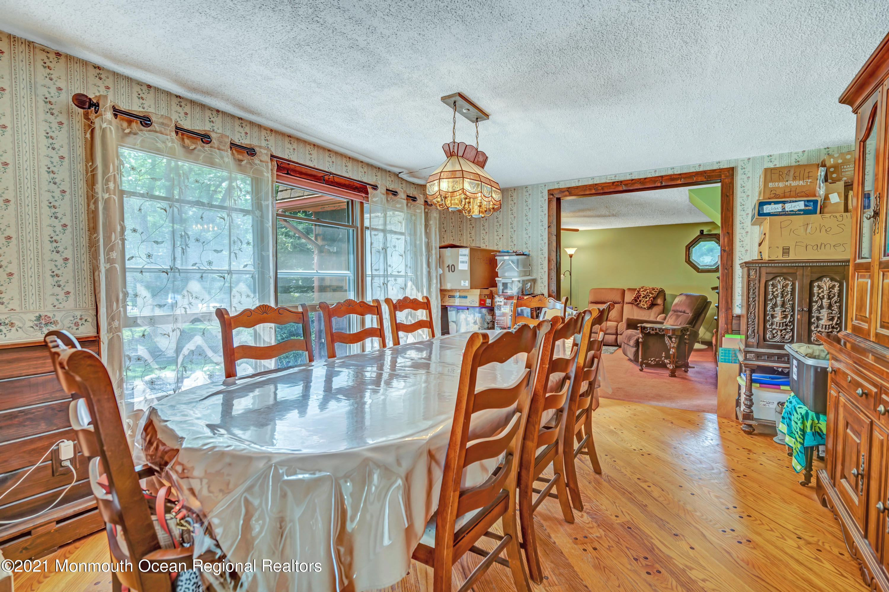 580 Hyson Road Jackson, NJ 08527 - Photo 16 of 45 a dining room filled with lots of glass windows and a chandelier