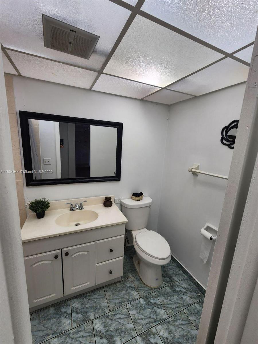 3690 Inverrary Drive, Unit 1T Lauderhill, FL 33319 - Photo 14 of 24 a bathroom with a toilet sink and mirror