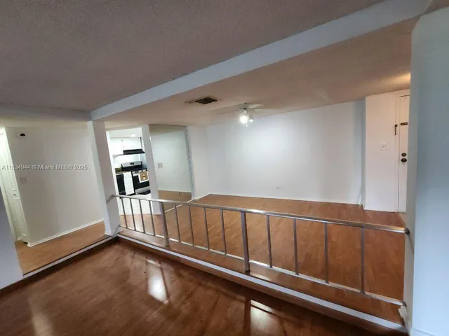 a view of an empty room with wooden floor