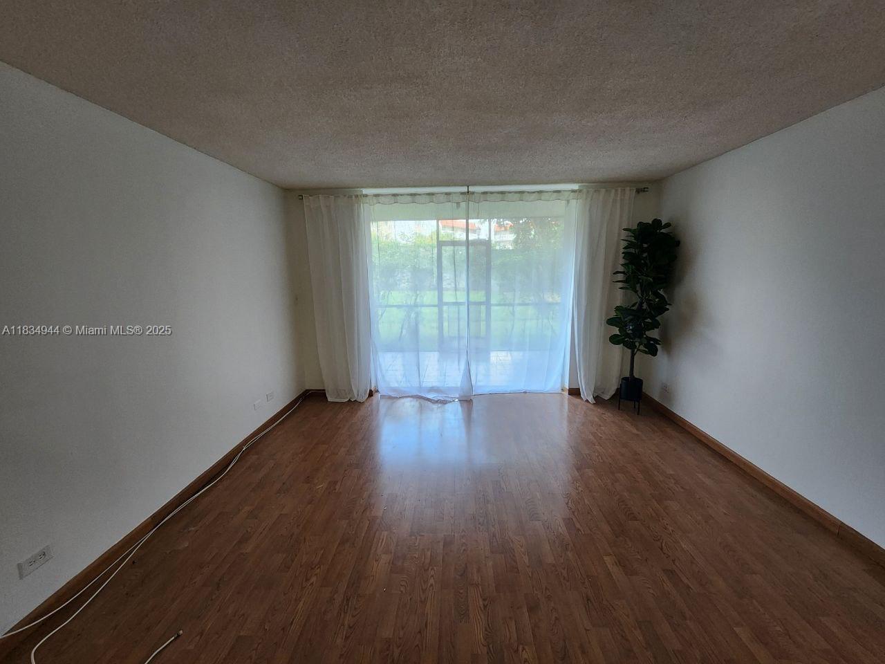 3690 Inverrary Drive, Unit 1T Lauderhill, FL 33319 - Photo 24 of 24 an empty room with wooden floor and windows