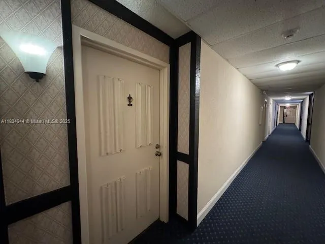 a view of a hallway with wooden floor and windows
