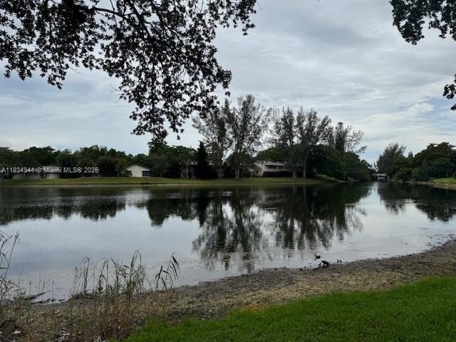 3690 Inverrary Drive, Unit 1T Lauderhill, FL 33319 - Photo 8 of 24 a view of a lake with a yard and large trees