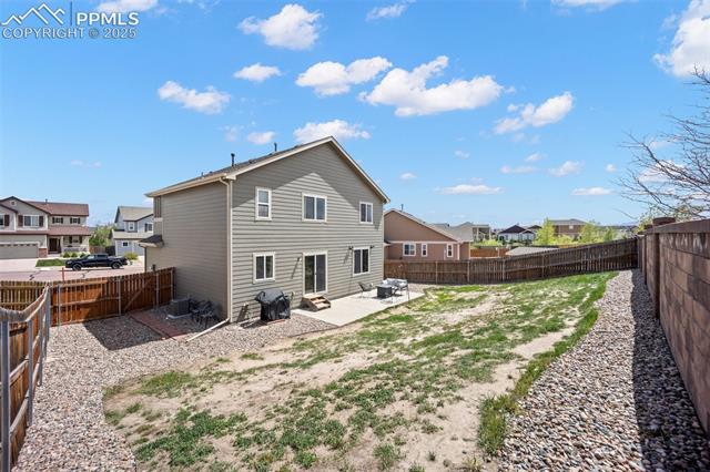 7148 Red Cardinal Loop Colorado Springs, CO 80908 - Photo 42 of 50 Rear view of house with a residential view, a patio, and a fenced backyard