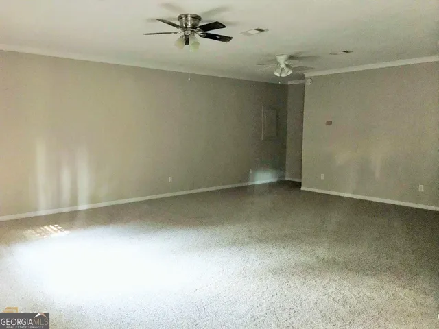 an empty room with a ceiling fan and a window