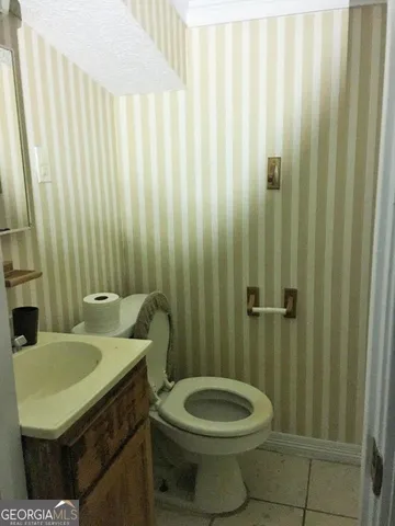 a bathroom with a sink a toilet and shower curtain