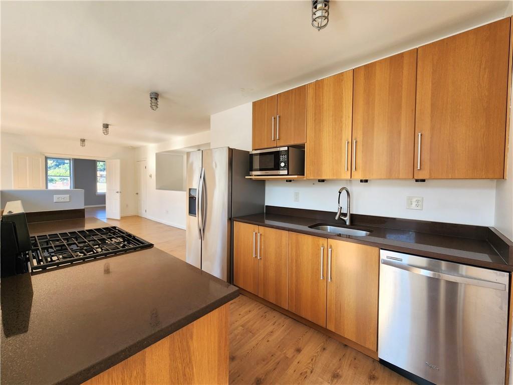 5326 Butler Street, Unit 3 Pittsburgh, PA 15201 - Photo 2 of 6 a kitchen with stainless steel appliances granite countertop a sink stove and refrigerator