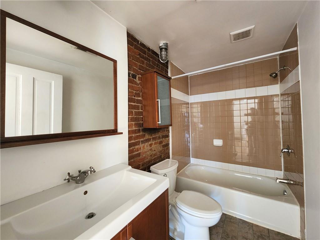 5326 Butler Street, Unit 3 Pittsburgh, PA 15201 - Photo 4 of 6 a bathroom with a sink a toilet and shower