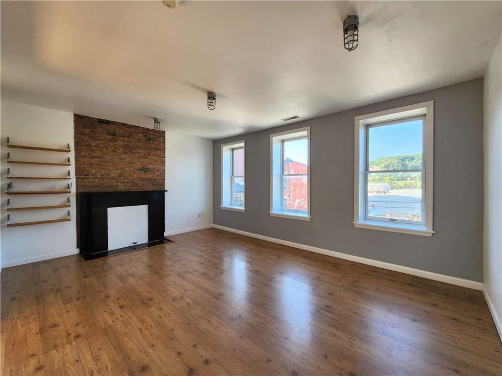 5326 Butler Street, Unit 3 Pittsburgh, PA 15201 - Photo 6 of 6 a view of an empty room with wooden floor and a window