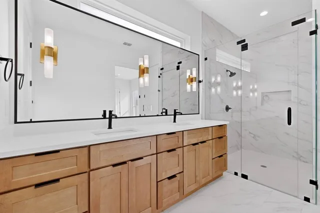 a spacious bathroom with a double vanity sink a mirror and a bathtub