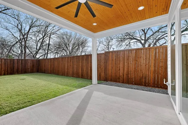 a view of a house with backyard and wooden fence