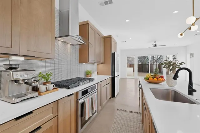 a kitchen with granite countertop a sink a stove and cabinets