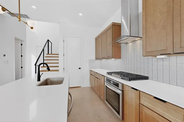 a kitchen with a sink a stove and cabinets
