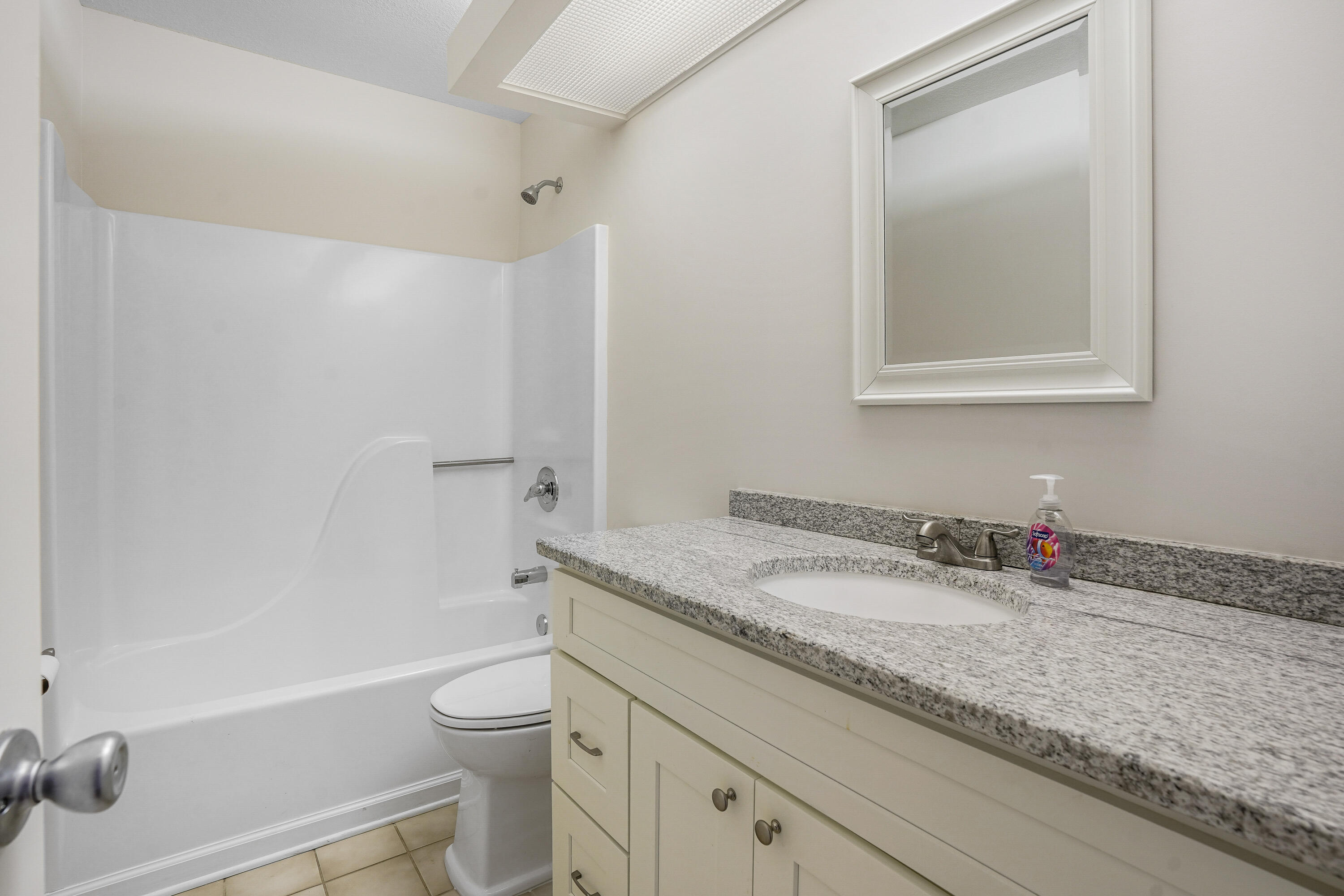23 Lake Vista Trail, Unit 101 Port St. Lucie, FL 34952 - Photo 13 of 24 a bathroom with a granite countertop toilet a sink and a bathtub