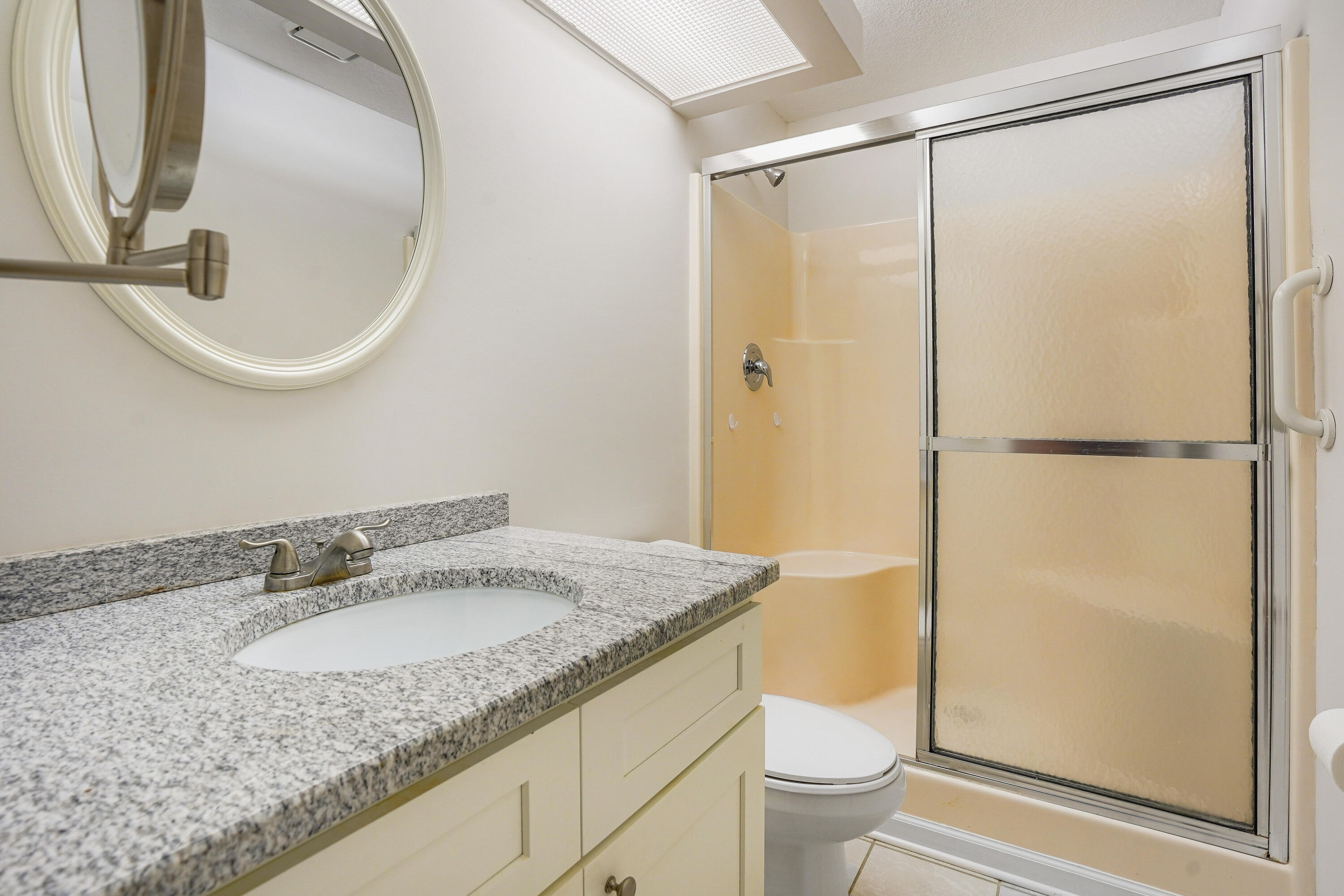 23 Lake Vista Trail, Unit 101 Port St. Lucie, FL 34952 - Photo 17 of 24 a bathroom with a granite countertop sink toilet and a mirror