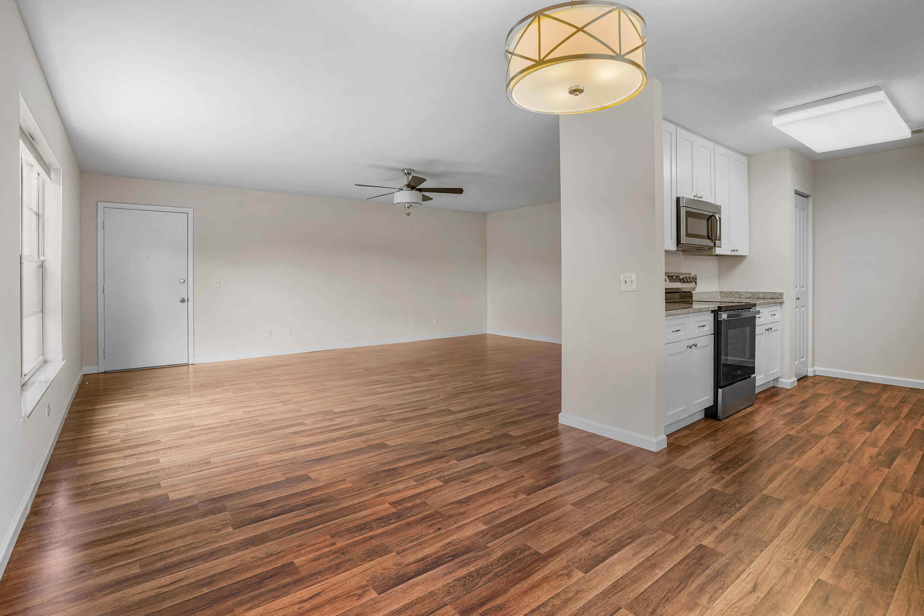 23 Lake Vista Trail, Unit 101 Port St. Lucie, FL 34952 - Photo 9 of 24 wooden floor in an empty room with a window