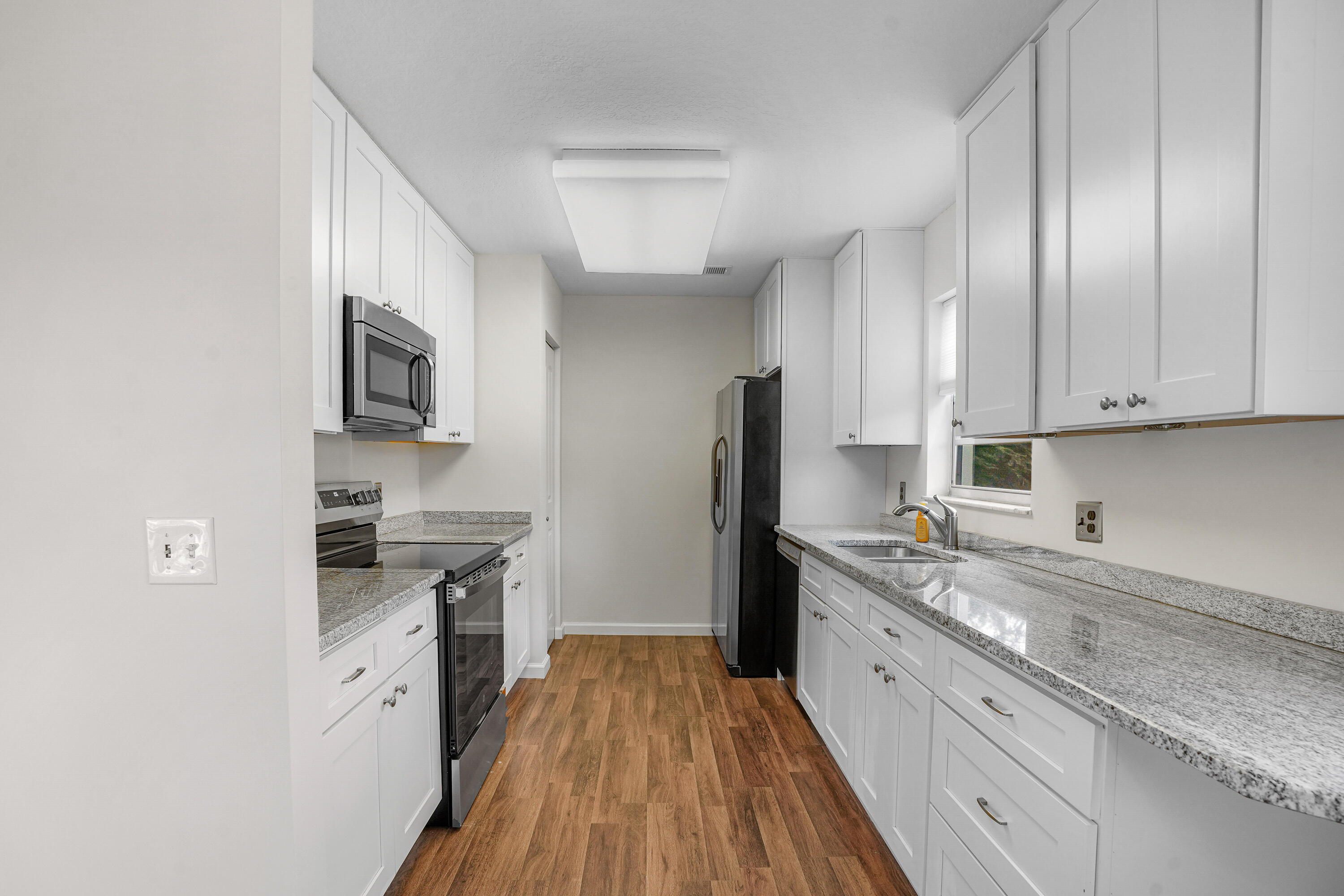 23 Lake Vista Trail, Unit 101 Port St. Lucie, FL 34952 - Photo 10 of 24 a kitchen with a sink stove and refrigerator