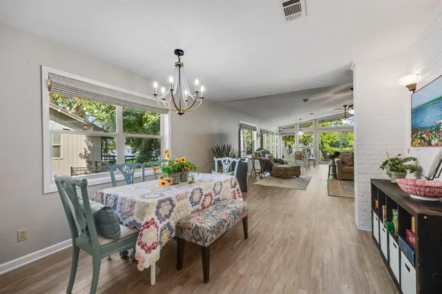 a view of a dining room with furniture a chandelier and wooden floor