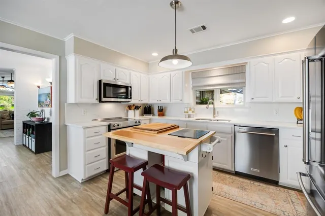 a kitchen with a center island appliances and cabinets