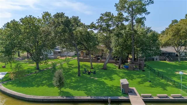 an aerial view of a residential house with outdoor space and lake view