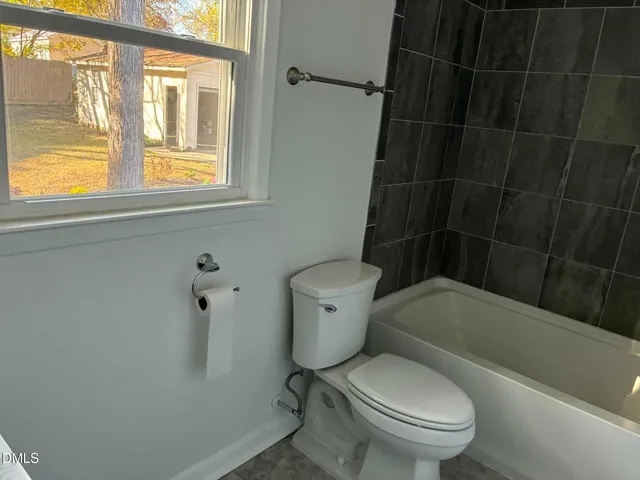 a white toilet sitting next to a window