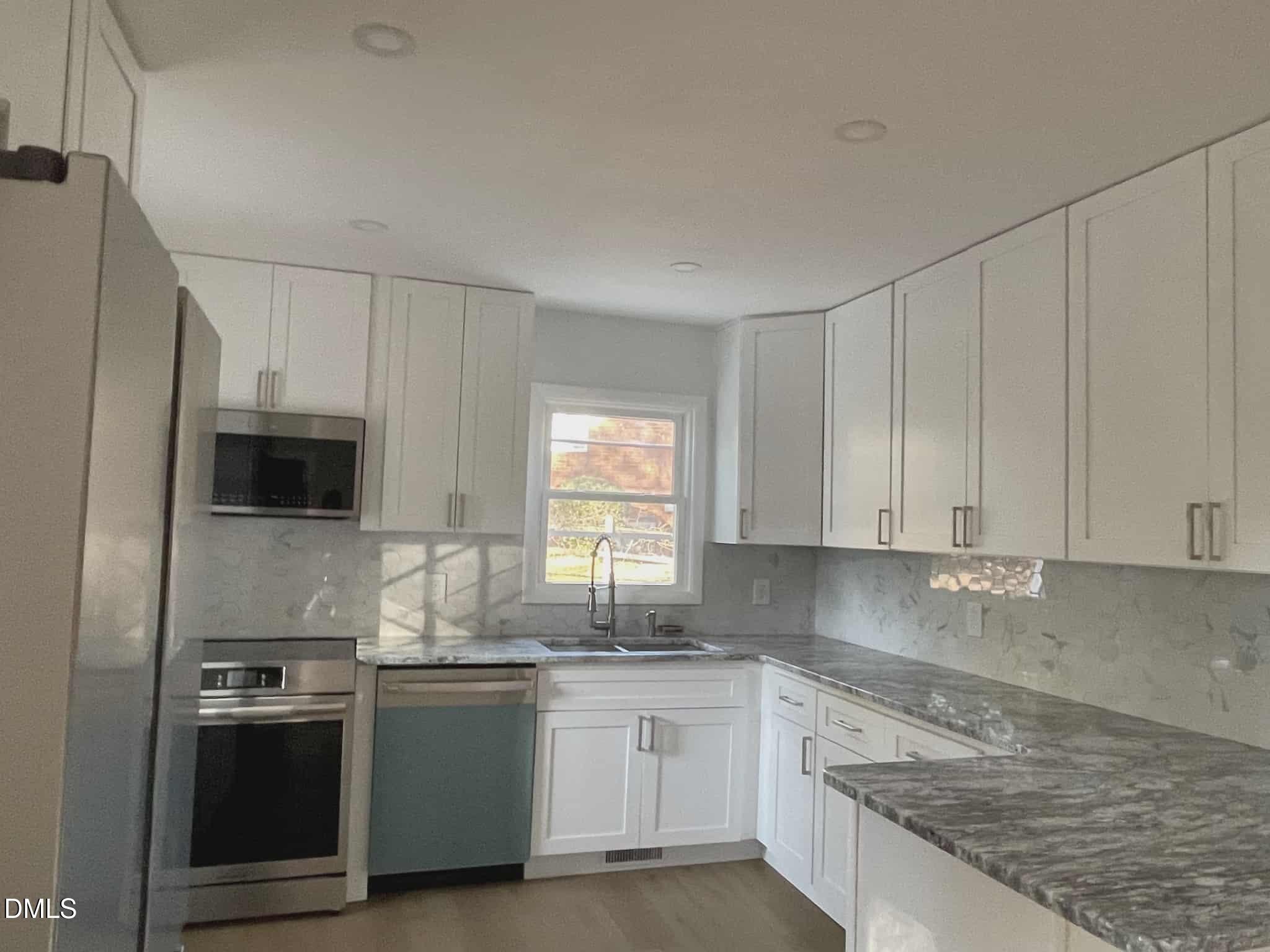 3415 Carolyn Drive Raleigh, NC 27604 - Photo 4 of 30 a kitchen with stainless steel appliances granite countertop a stove a sink and a refrigerator