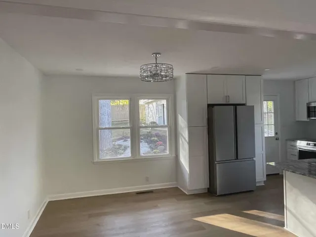 a view of a refrigerator in kitchen and wooden floor