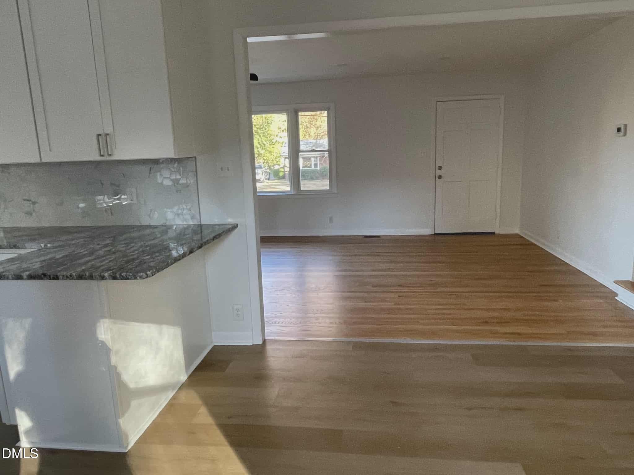 3415 Carolyn Drive Raleigh, NC 27604 - Photo 9 of 30 a view of an empty room with wooden floor and cabinets